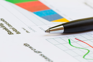 Financial report graph with pen on the table