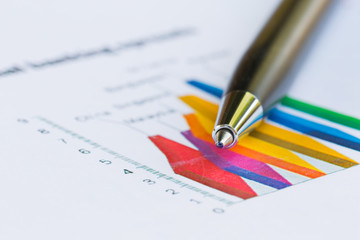 Financial report graph with pen on the table