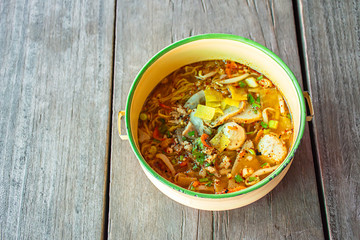 Spicy noodle soup with pork put the Pinto on wooden.