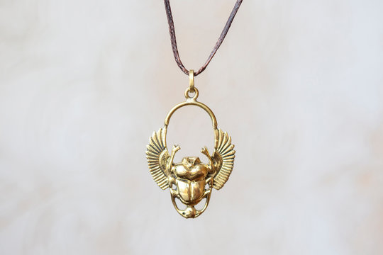 Brass metal scarabeus pendant round mandala on neutral background