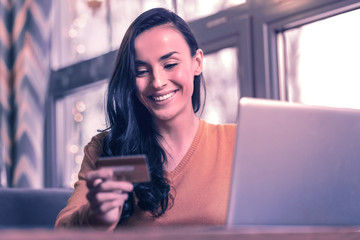 Delighted positive woman sitting near the laptop