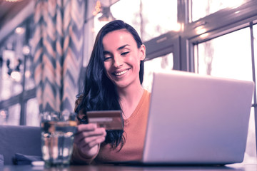 Joyful happy woman looking at the credit card data