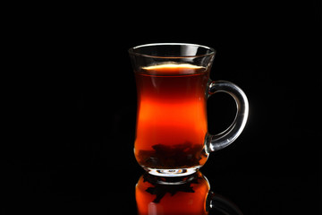 A glass of Turkish black tea on the black background