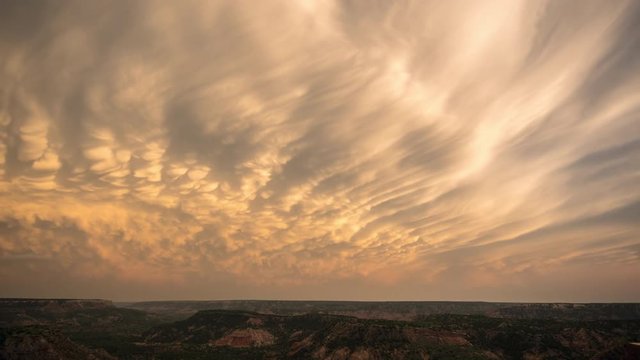 Time lapse of mammatus clouds changing color during colorful sunset over Palo Duro Canyon in Texas after a storm.