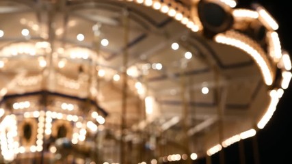 Illuminated blurred merry go round in park. Brightly illuminated roundabout spinning in wonderful amusement park at night.