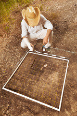 Archeologist on tropical location documenting his excavation work