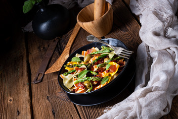 Pasta salad with green asparagus, olives and parma ham