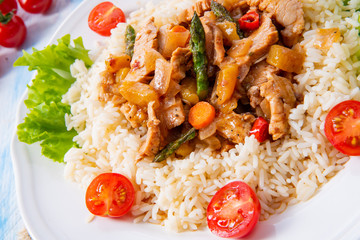 Turkey fricassee on rice with asparagus and paprika