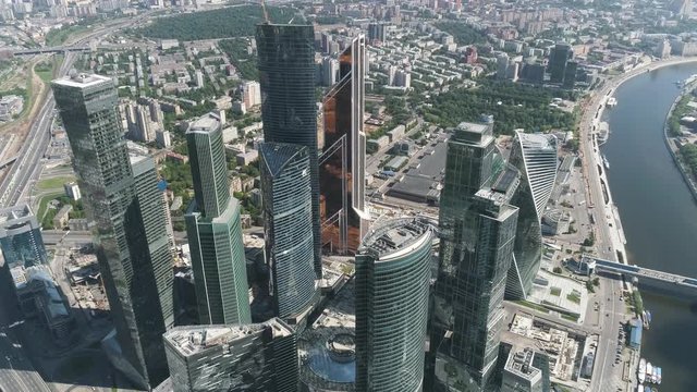 Aerial view of beautiful complex of modern glass office buildings, Moscow city, urban jungle concept. Action. Glass skyscrapers shot in a bright sunny day with glare on the glass.