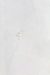 White wall with cracked plaster as abstract background