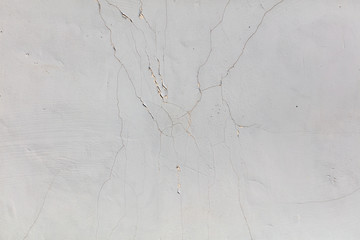 White wall with cracked plaster as abstract background