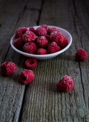 raspberries in a bowl on wooden table