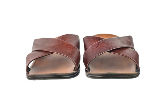 Pair of lightweight slippers for beach beside sea on vacation or domestic with two brown leather strips and plastic or rubber sole isolated on white background