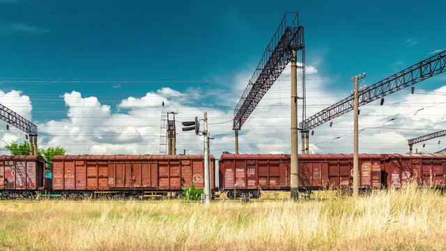 Railroad hopper cars at the background clouds and blue sky. Timelapse 4K