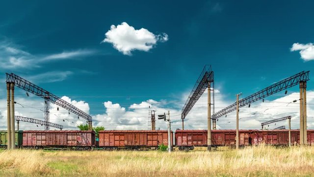 Freight railroad hopper train at the background clouds. Timelapse 4K