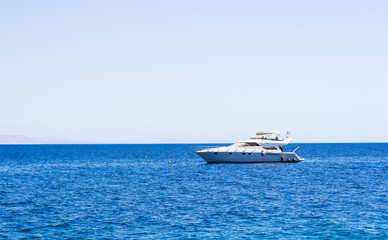 cruise vacation summer photography of white yacht on Red sea smooth blue water surface in bright clear weather time, copy space for text or some inscription 
