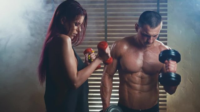 Playful girl and sporty muscular guy playing sports funny