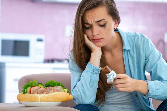 Sad, Unhappy Stressed Crying Woman Eating Unhealthy Junk Food And Chocolate Because Of Depression And Emotional Stress. Nerve Food. Life Problems And Difficulties. Food Addiction