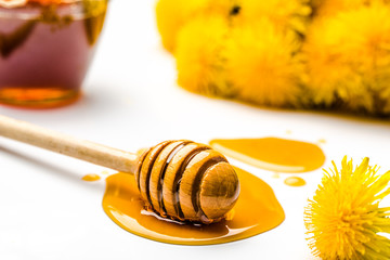 Dandelion honey - stick with drop of honey on white background