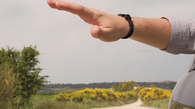 Mano fluttua fuori dal finestrino di una macchina