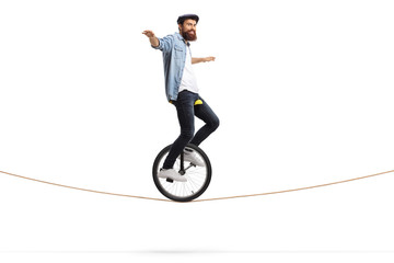 Man riding a unicycle on a rope and balancing with his hands © Ljupco Smokovski