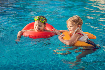 two little kids playing in the swimming pool