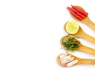 Seasoning food Chill pepper,Lime leaves,lime and lemon grass in wooden spoon isolate on white background