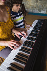 Fototapeta na wymiar Children's and women's hands on the piano keys.