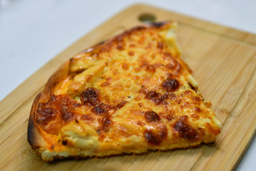 Slice of pizza Margherita on a wooden board