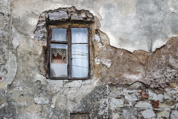 Old broken window in the old facade of the building.