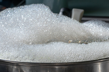close up of pot full of suds and bubbles for washing dishes