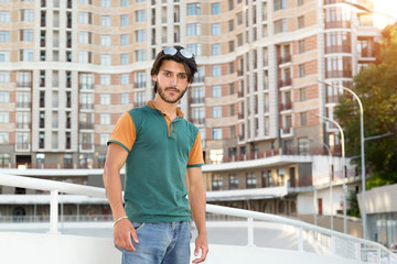 Brunette man with glasses against the background of the urban building.