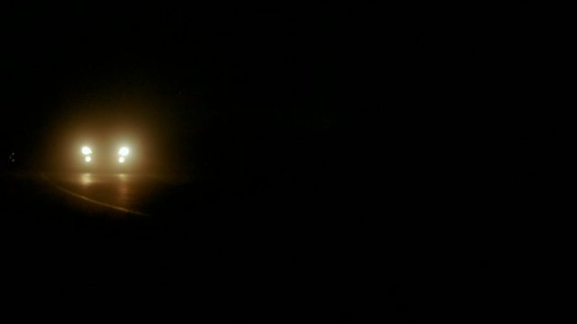 Car driving on country road at dusk through forest with headlights in Torrevieja, Spain. 4K