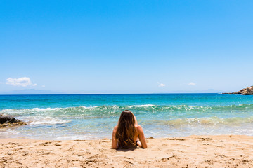 Junge Frau liegt an einem Strand auf Paros, Griechenland