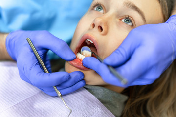 Dental clinic. Reception, examination of the patient. Teeth care. Young woman undergoes a dental examination by a dentist