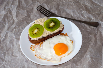 Delicious and healthy breakfast. Scrambled eggs and kiwi sandwich