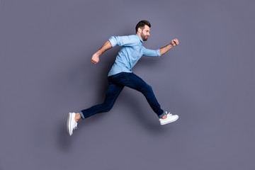 Fototapeta na wymiar Full length body size profile side view portrait of his he nice-looking attractive cheerful guy having fun running fast isolated over gray violet purple pastel background