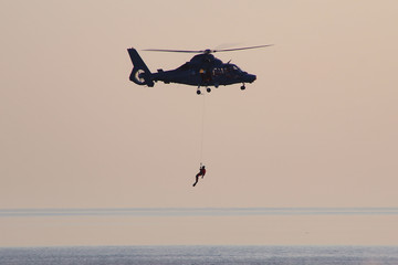 Rescue helicopter during an exercise. Rescue of the person at sea by helicopter. © vaitekune