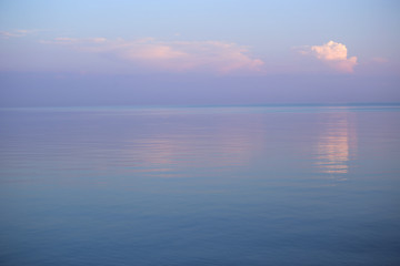 Fototapeta premium Background of seascape in sunset. Calm sea and purple sky with clouds. 