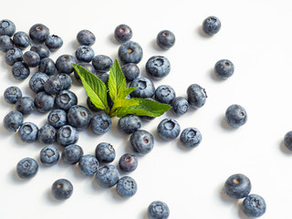 Closeup summer blueberries with a mint leaf isolated on white background