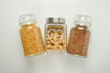 Various raw cereals in glass jar. Zero waste concept. Food storage. Flat lay. White background.