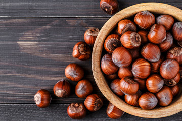 Filtered image of Hazelnuts in a wooden bowl on rustic background,top view.