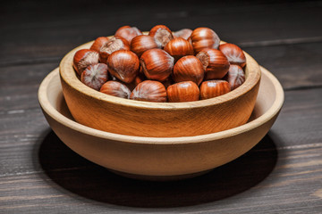 Filtered image of Hazelnuts in a wooden bowl on rustic background,top view.