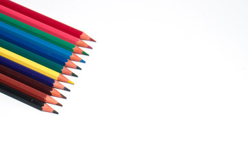 Color pencils on white background top view. At the bottom right there is place to insert text.