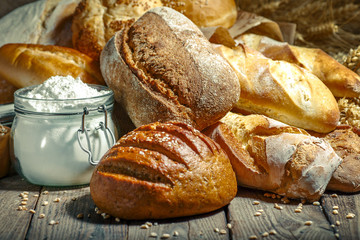 Assortment of baked bread on wooden table background