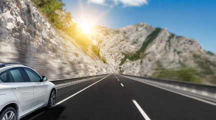 White car rushing along a high-speed highway. Toned photo.