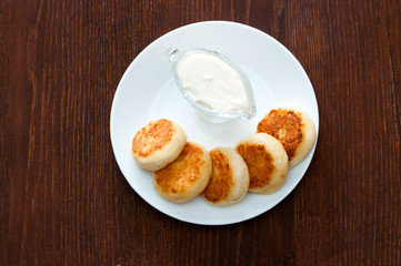 Fried cheesecakes with sour cream top view. For cafe or restaurant menu design.