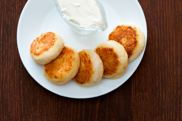 Fried cheese pancakes with sour cream, view from above