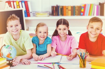 Fototapeta premium Friendly school children with books at class