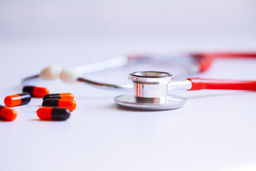 stethoscope for doctor checkup with pills on medical laboratory table